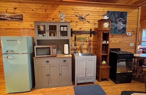 Pleasant Grove Cabin | Riverfront cabin with hot tub and amenities galore!